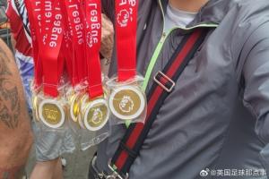 球迷在阿森纳冠军巡游卖奖牌，撕开贴纸写着：利物浦是冠军！